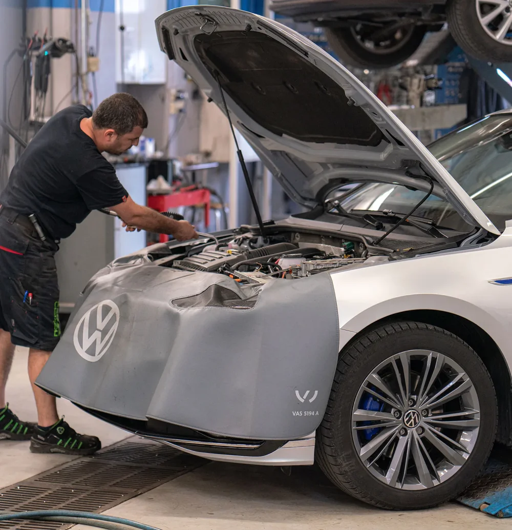 LMS Servicen asentaja lisäämässä laadukasta moottoriöljyä Volkswagen-henkilöautoon määräaikaishuollon yhteydessä Turussa.